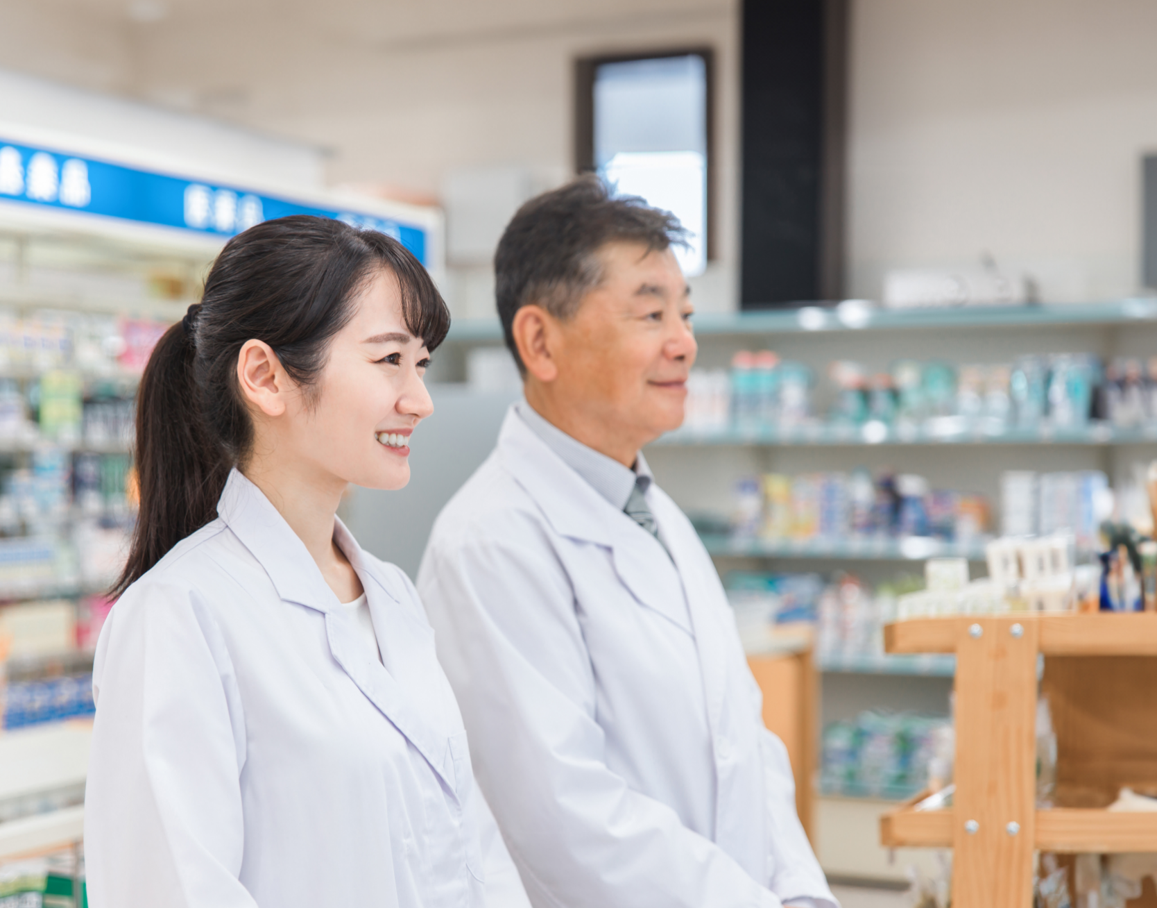 笑顔で働くベテラン薬剤師と若手薬剤師